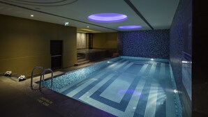 A swimming pool with a tiled floor and a blue mosaic wall. - Titanic City Taksim (Istanbul)