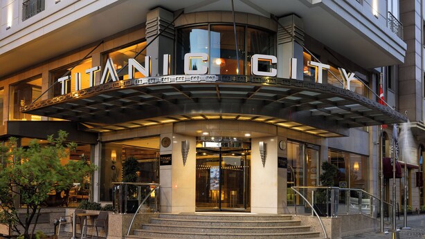 A modern hotel entrance with a curved canopy and the name "TITANIC CITY" prominently displayed. - Titanic City Taksim (Istanbul)