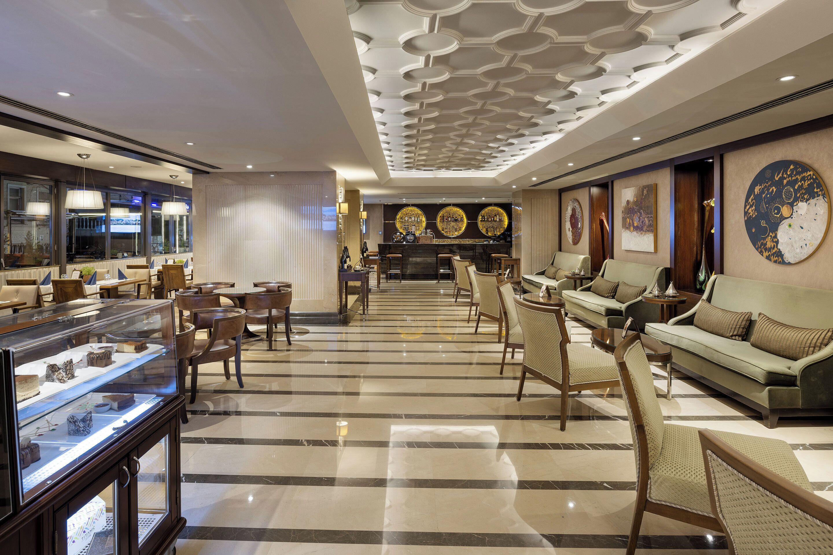 A spacious lobby with a central bar area, seating arrangements, and a display case with items.