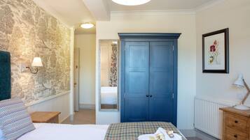 Un dormitorio con cama, cómoda, espejo y puerta que da a otra habitación.
