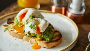 A breakfast dish with poached eggs, avocado, and greens on toast. - The Kings Arms Hotel - Inn (Melksham)