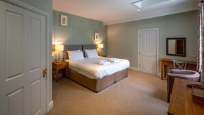 A bedroom with a large bed, bedside tables, a desk, and a chair. - The Kings Arms Hotel - Inn (Melksham)