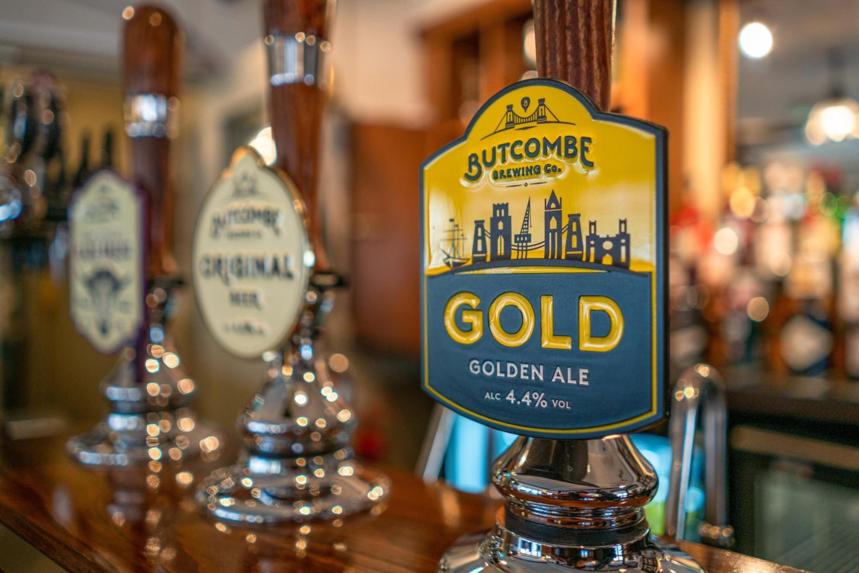 Un bar con un grifo que dice "Butcombe Brewing Co. GOLDEN ALE".