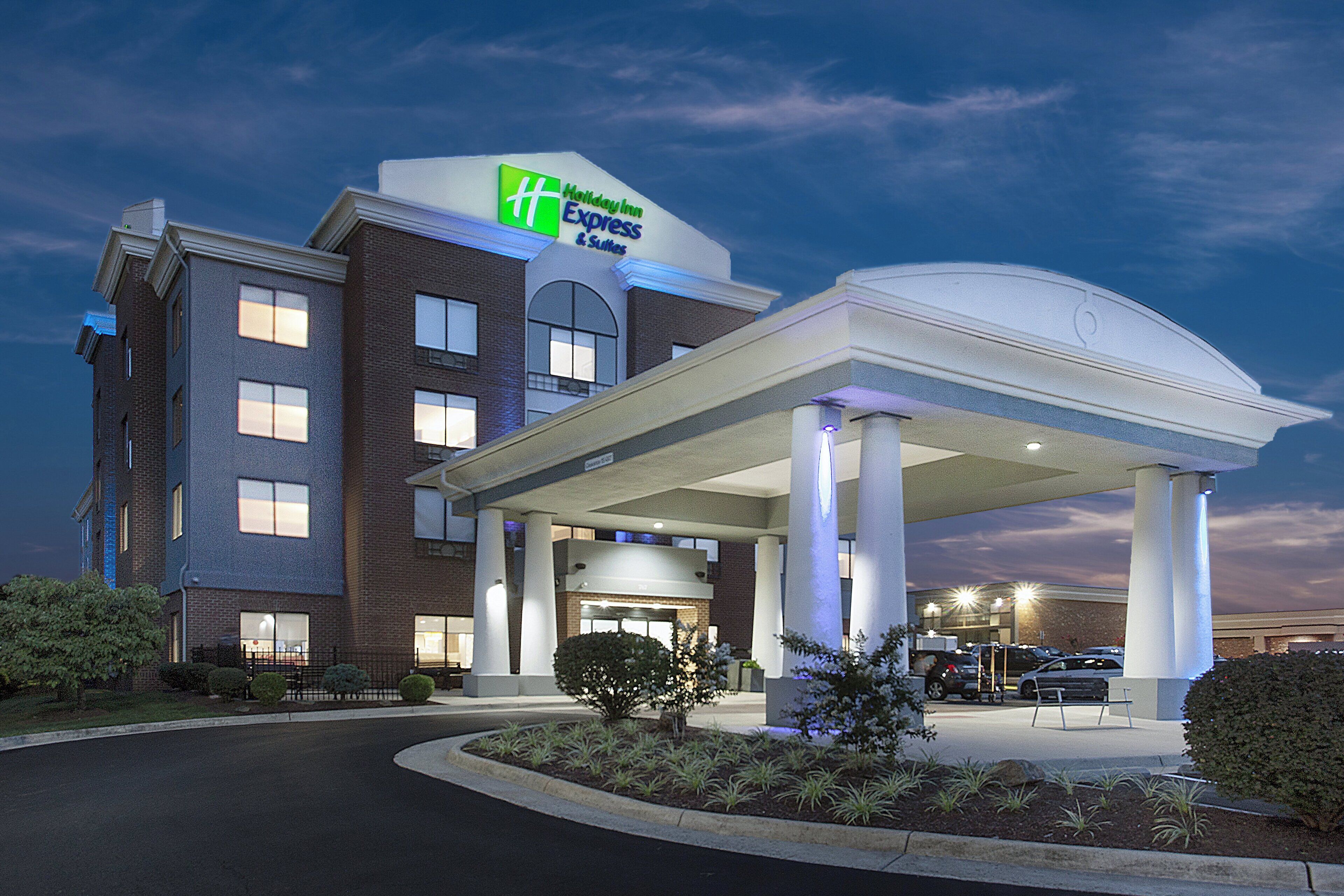 A Holiday Inn Express & Suites with a covered entrance and a landscaped driveway.