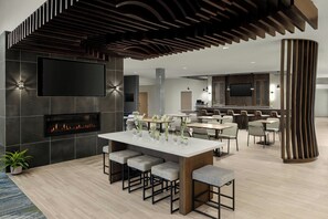Une cuisine moderne dotée d’un grand îlot central, d’un coin bar et d’une cheminée.