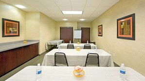 A conference room with tables, chairs, a reception desk, and framed artwork on the walls. - Holiday Inn Express & Suites Willcox by IHG (Willcox)