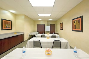 A conference room with tables, chairs, a reception desk, and framed artwork on the walls. - Holiday Inn Express & Suites Willcox by IHG (Willcox)
