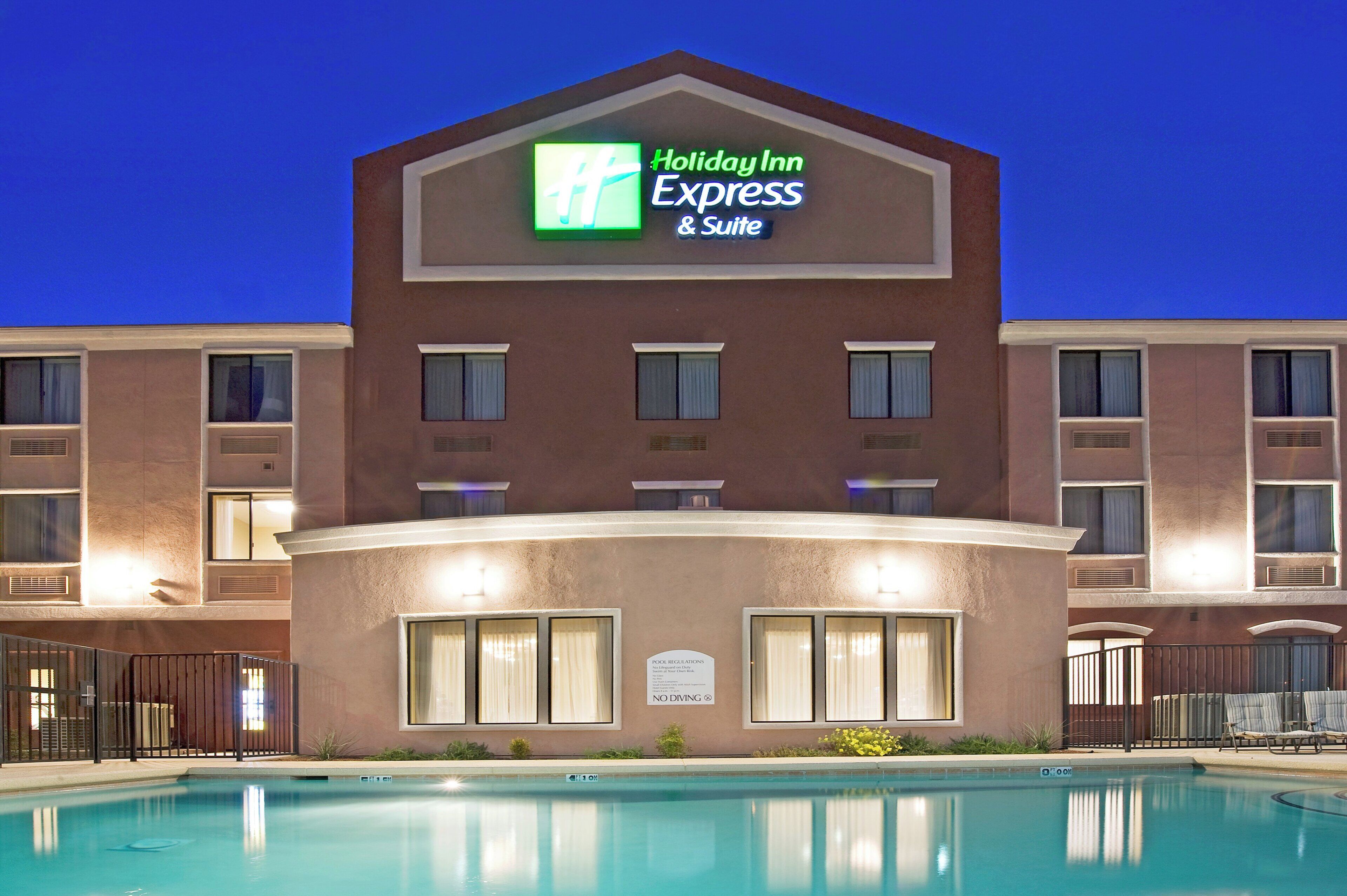 Edificio de Holiday Inn Express con una piscina delantera.