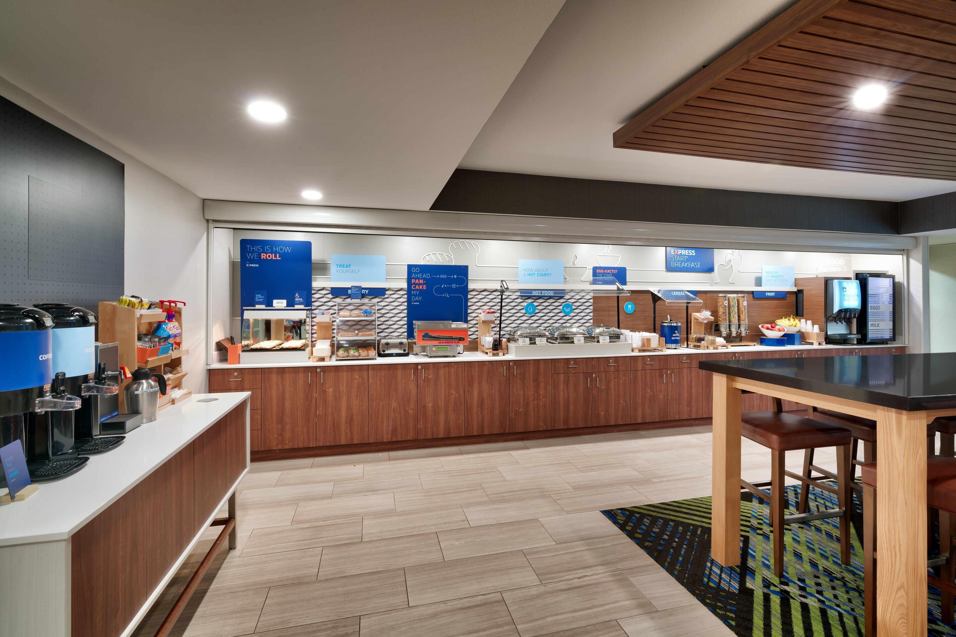A modern kitchen with a central island, built-in appliances, and a breakfast bar.