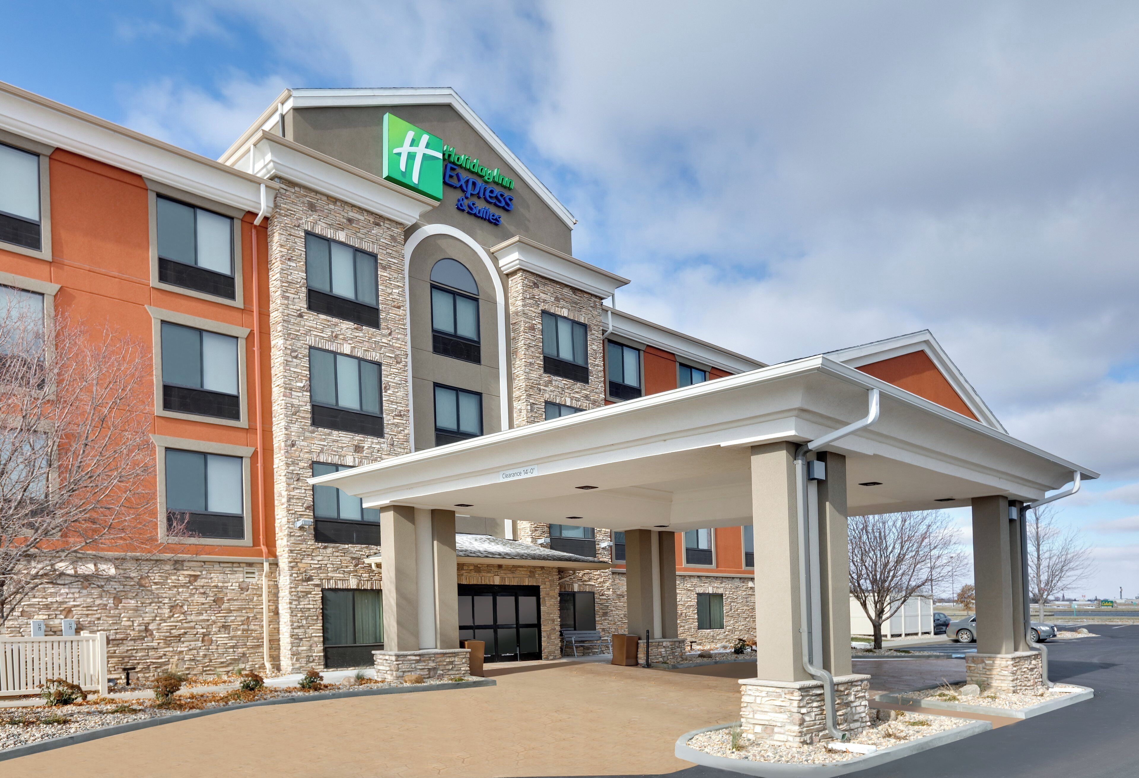 A Holiday Inn Express & Suites hotel with a covered entrance and a stone facade.