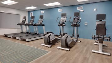 A fitness room with treadmills, elliptical machines, and a stationary bike.