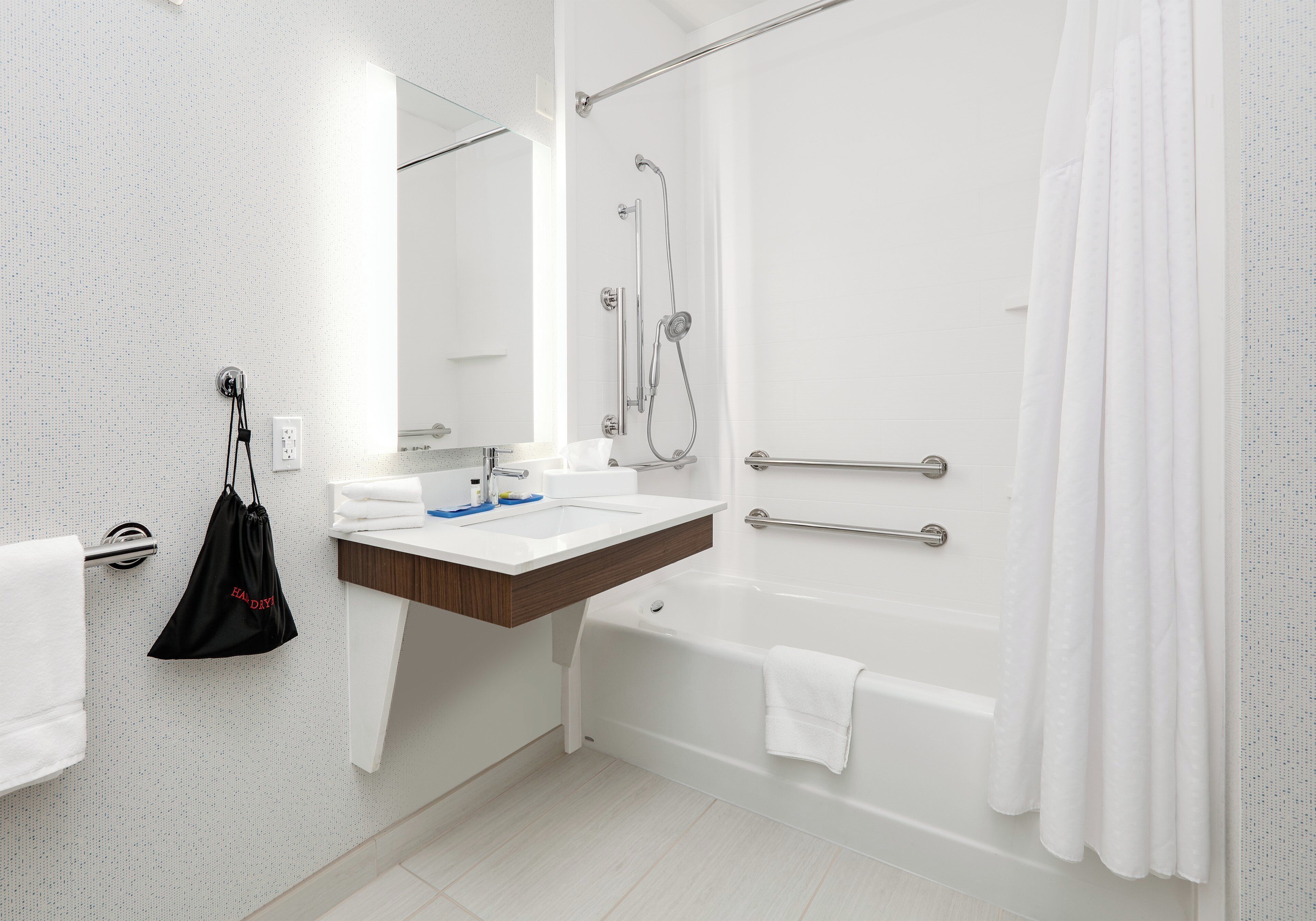 A modern bathroom with a shower, a sink, and a toilet.