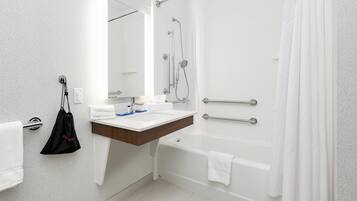 A modern bathroom with a shower, a sink, and a toilet.