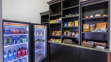 En automat fyldt med forskellige drikkevarer og snacks, blandt andet sodavand, chips og andre forpakning.