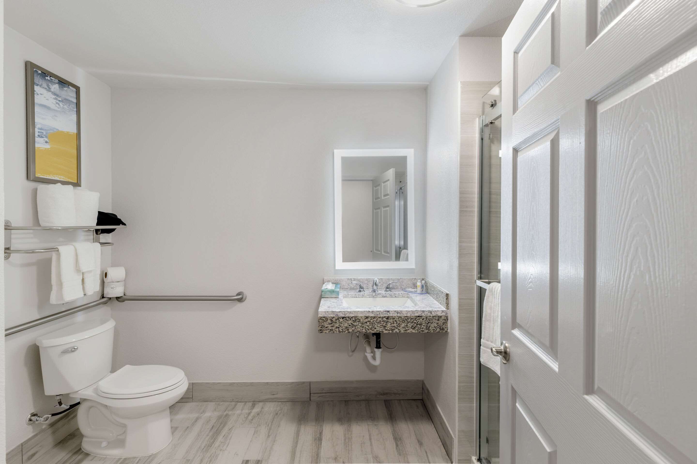 A bathroom with a toilet, sink, and shower area.