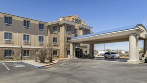 A Comfort Inn hotel with a covered entrance and a handicap parking sign.