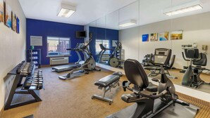 A fitness center with treadmills, elliptical machines, and free weights.