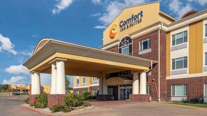 A Comfort Inn & Suites hotel with a covered entrance and brick facade.