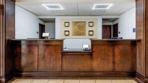 A reception desk with a large wall-mounted clock and a "Welcome" sign.