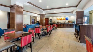 A spacious hotel lobby with a central bar area, multiple seating arrangements, and a modern design.