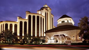 A large hotel with a prominent tower and a fountain in front. - L'Auberge Casino Resort Lake Charles (Lake Charles)