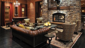 A cozy lounge area with a stone fireplace, leather sofa, and patterned chairs. - L'Auberge Casino Resort Lake Charles (Lake Charles)