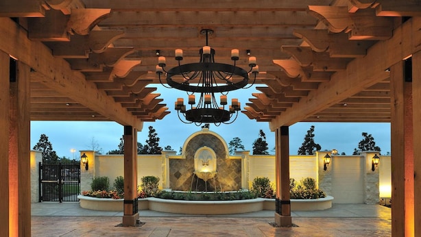 A covered outdoor area with a central fountain, wooden pergola, and stone walls. - L'Auberge Casino Resort Lake Charles (Lake Charles)