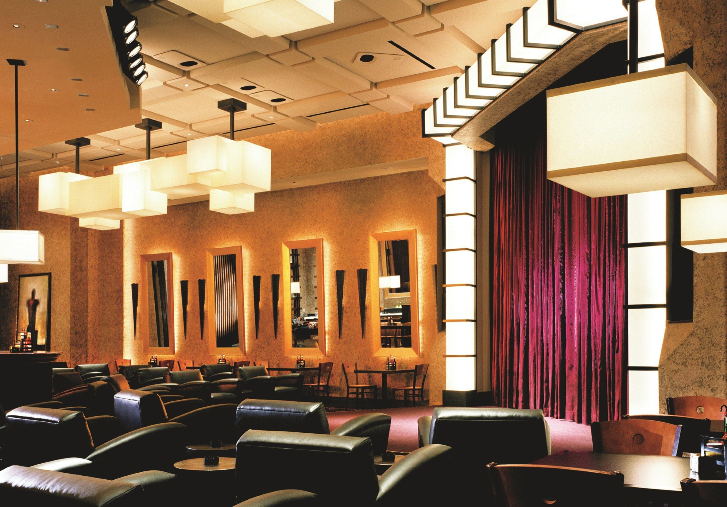 A hotel lobby with leather seating, large windows, and modern lighting fixtures.