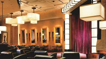 A hotel lobby with leather seating, large windows, and modern lighting fixtures.