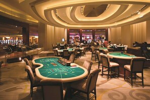 A casino with multiple blackjack tables and a bar area. - MGM Tower at Borgata (Atlantic City)