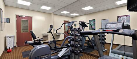A gym with treadmills, elliptical machines, and weight equipment.