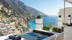 A rooftop pool with a view of the sea and a coastal town. - Hotel Villa Franca (Positano)