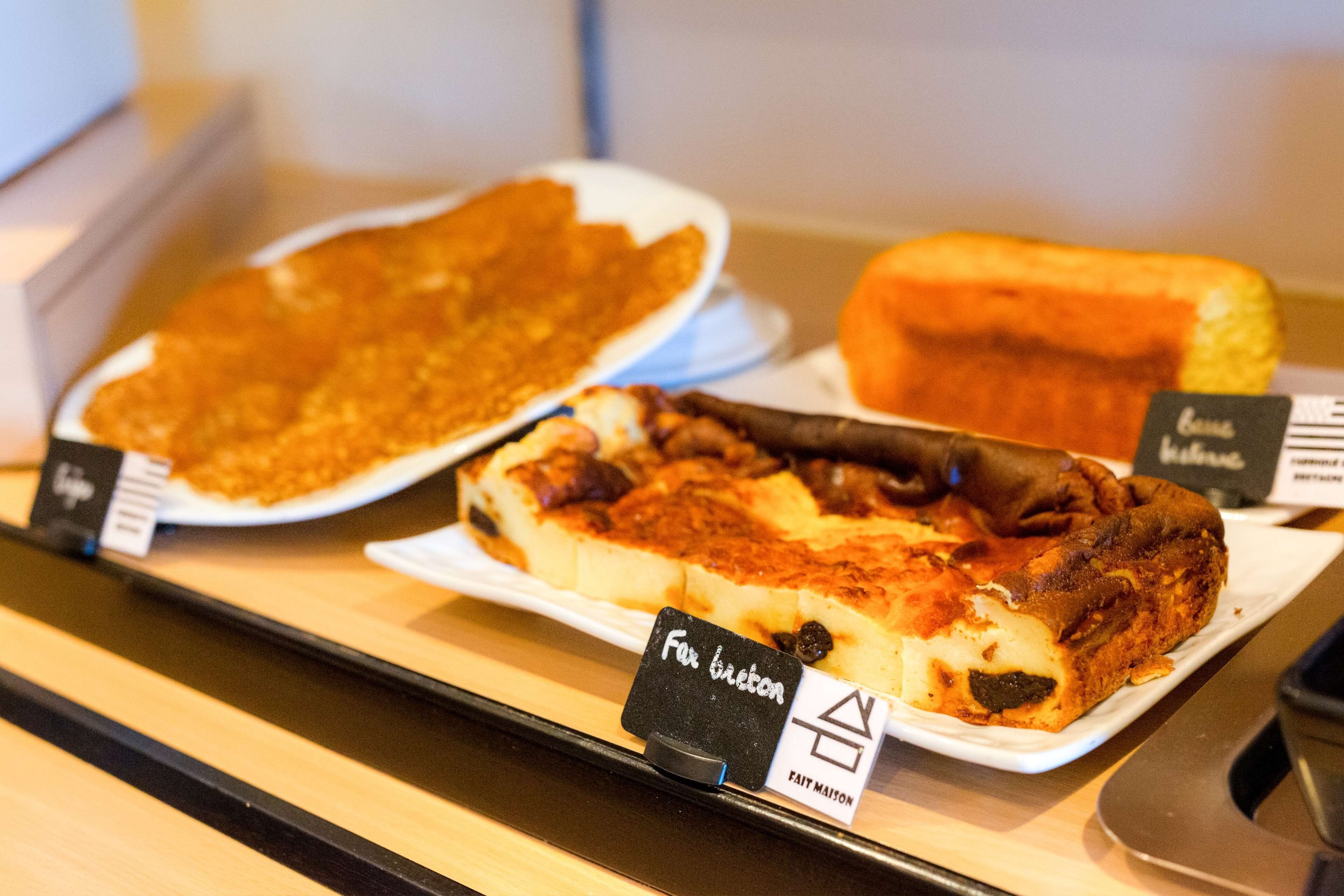 A display of various baked goods, including a pie and a bread, with price tags.