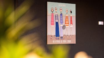 A wall with a colorful illustration of four figures in different outfits, with the text "Bienvenue" and "Au Kyriad de Pont L'Abbé" visible.