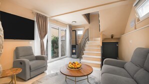 A living room with a sofa, a coffee table with fruit, a TV, and a staircase. - Villa Matejuska Heritage (Split)