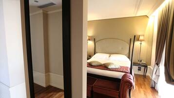 A hotel room with a bed, bedside lamps, a nightstand, and a mirror.