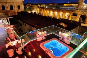 A rooftop terrace with a hot tub, seating area, and a view of historic architecture. - Hotel Milano & Spa (Verona)