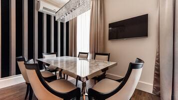 Una sala da pranzo moderna con un tavolo in marmo, sei sedie, un lampadario e un grande quadro appeso al muro.