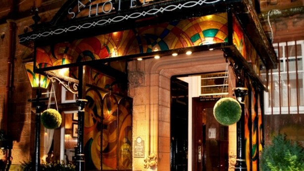 A hotel entrance with a red carpet, a sign reading "Savoy Park Hotel," and a colorful stained glass window. - Savoy Park Hotel (Ayr)