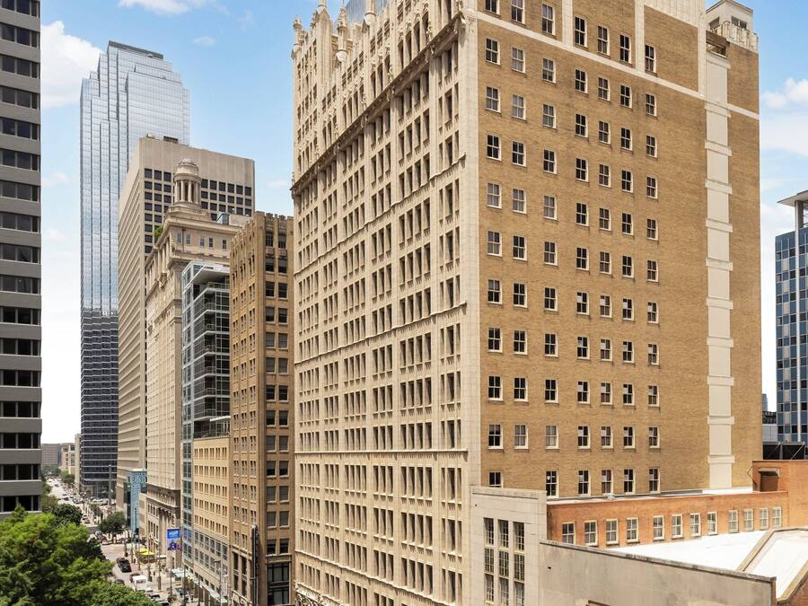 Un edificio histórico con fachada simétrica, ventanas amplias y una entrada central.