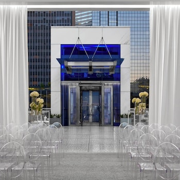 Enter a sophisticated space with a glass door, white curtains, and elegant flower arrangements. at The Joule