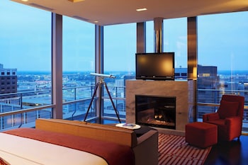 Relax in comfort with a panoramic city view, a comfortable bed, and a cozy fireplace. at The Joule