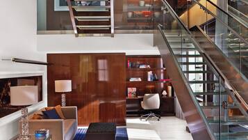 Un intérieur moderne avec un escalier, un canapé, une table basse et une bibliothèque.