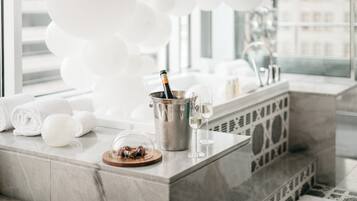 Une salle de bain moderne avec un comptoir en marbre, une bouteille de champagne et un verre de champagne.