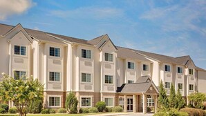 A multi-story hotel with a symmetrical facade, large windows, and a covered entrance area.
