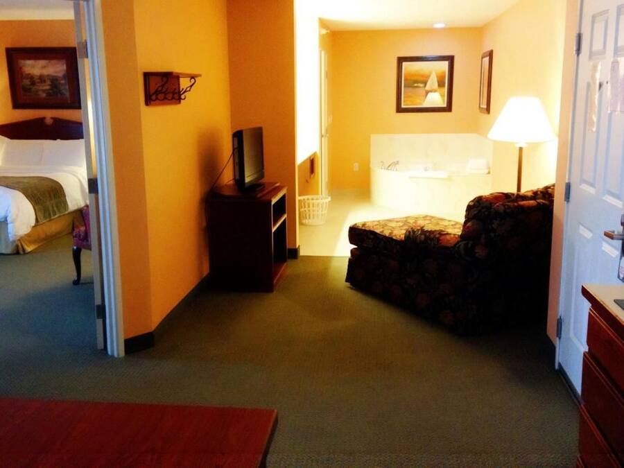 A hotel room with a bed, a TV, a sofa, a desk, and a bathroom.