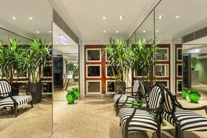 Relax in the stylish lobby, featuring a seating area with striped chairs and a lush potted plant.