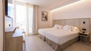 A hotel room with a bed, a desk, a chair, a TV, a bedside table, and a window with curtains. - Hotel Gran Sol Ibiza (Sant Antoni de Portmany)