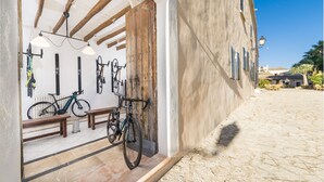 Un edificio con fachada de piedra, vigas de madera y un aparcamiento para bicicletas en el exterior.