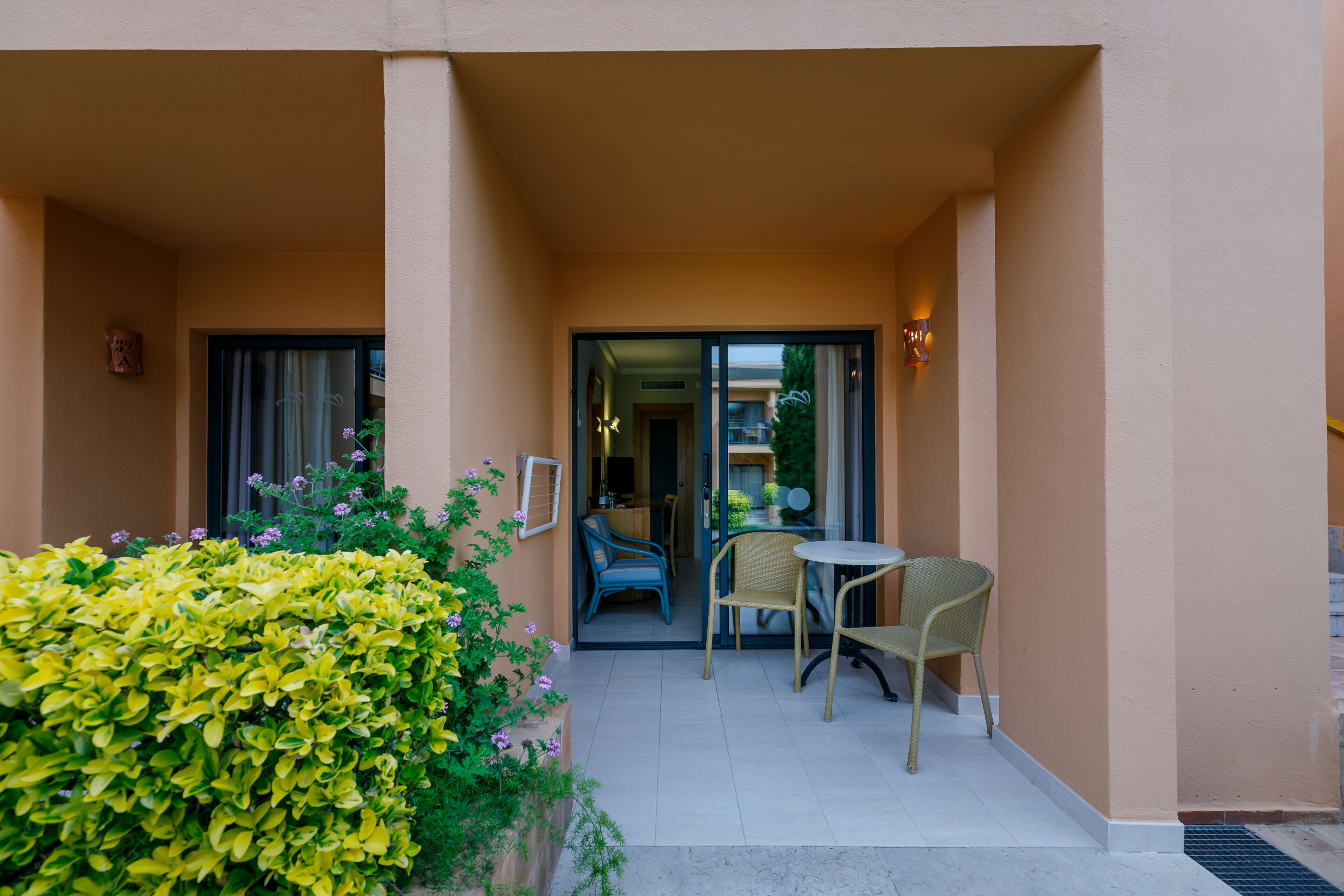 A covered outdoor area with a seating arrangement and a door leading to an interior space.